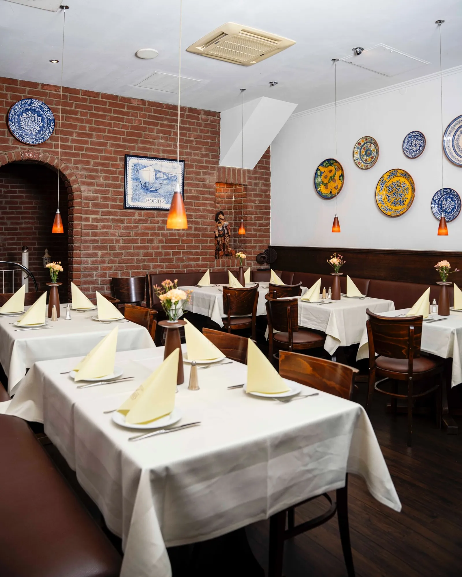 Der helle Gastraum des Restaurante Porto mit portugiesischen Tellern an der Wand